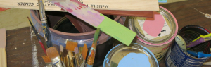 Photo of paint cans and brushes used by artists and youth creating the Sprott Youth Center mural.