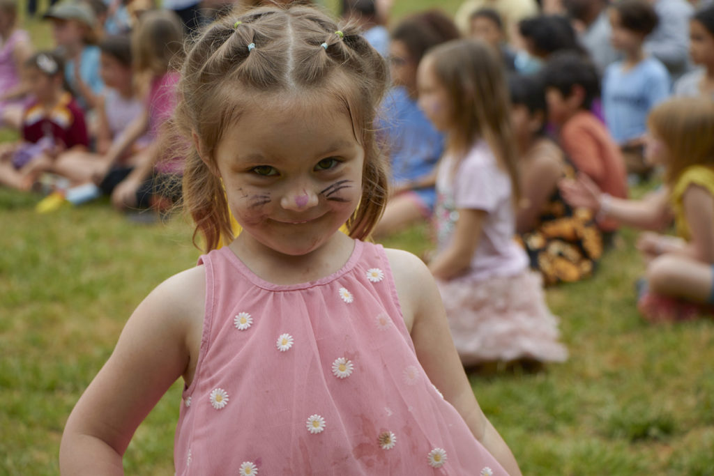 Photo of young girl with her face painted with cat whiskers