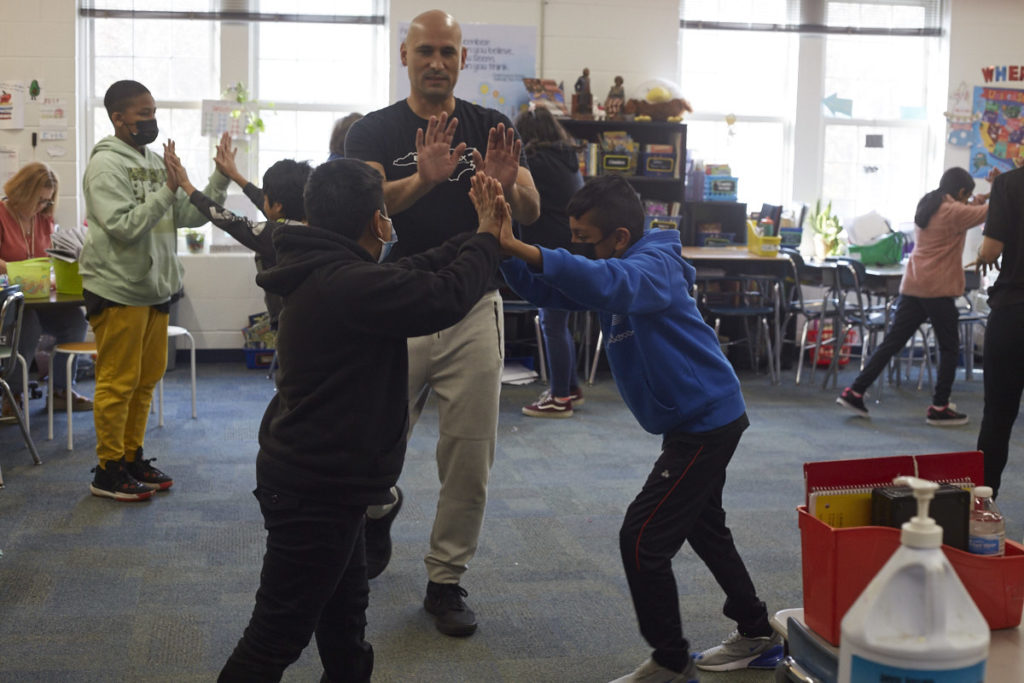 Black Box Dance instructor Alfredo assists 2 students at Silk Hope with a 50/50 exercise