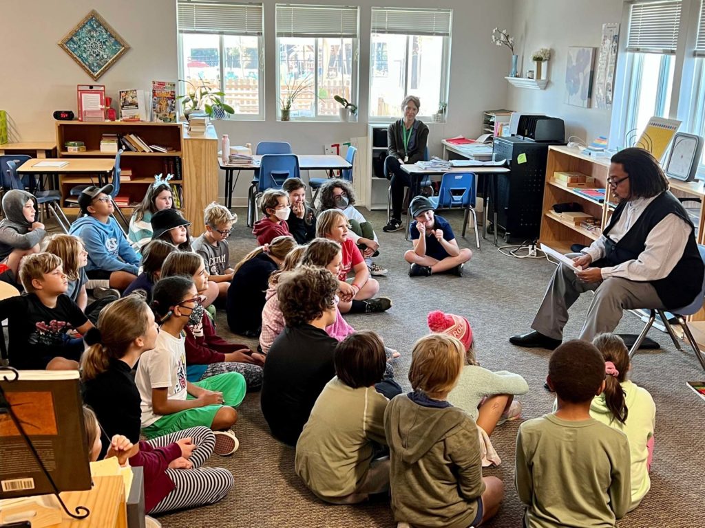 Photo of NC poet Phillip Shabazz reading to students at Willow Oak Montessori