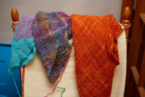 Photo of brightly colored shawls Chana has woven