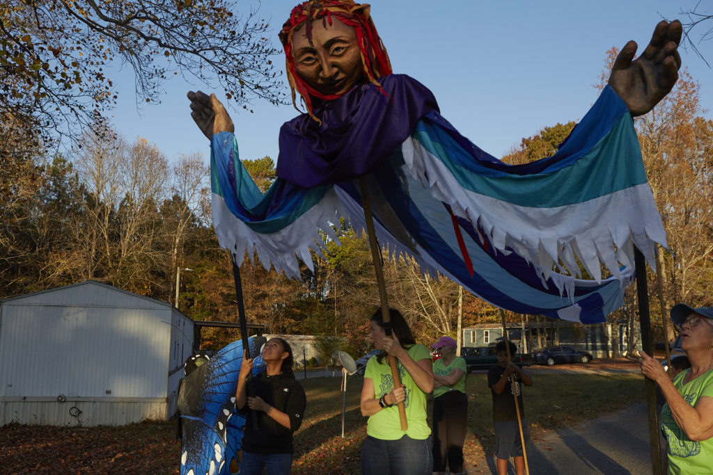 Photo of giant 5-person puppet being handled by neighborhoods kids and CAC staff