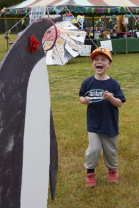 Photo of young boy ecstatic after success at the penguin ring toss