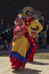Members of Takiri Folclor Latino, in brightly colored costumes dance at ClydeFEST 2023