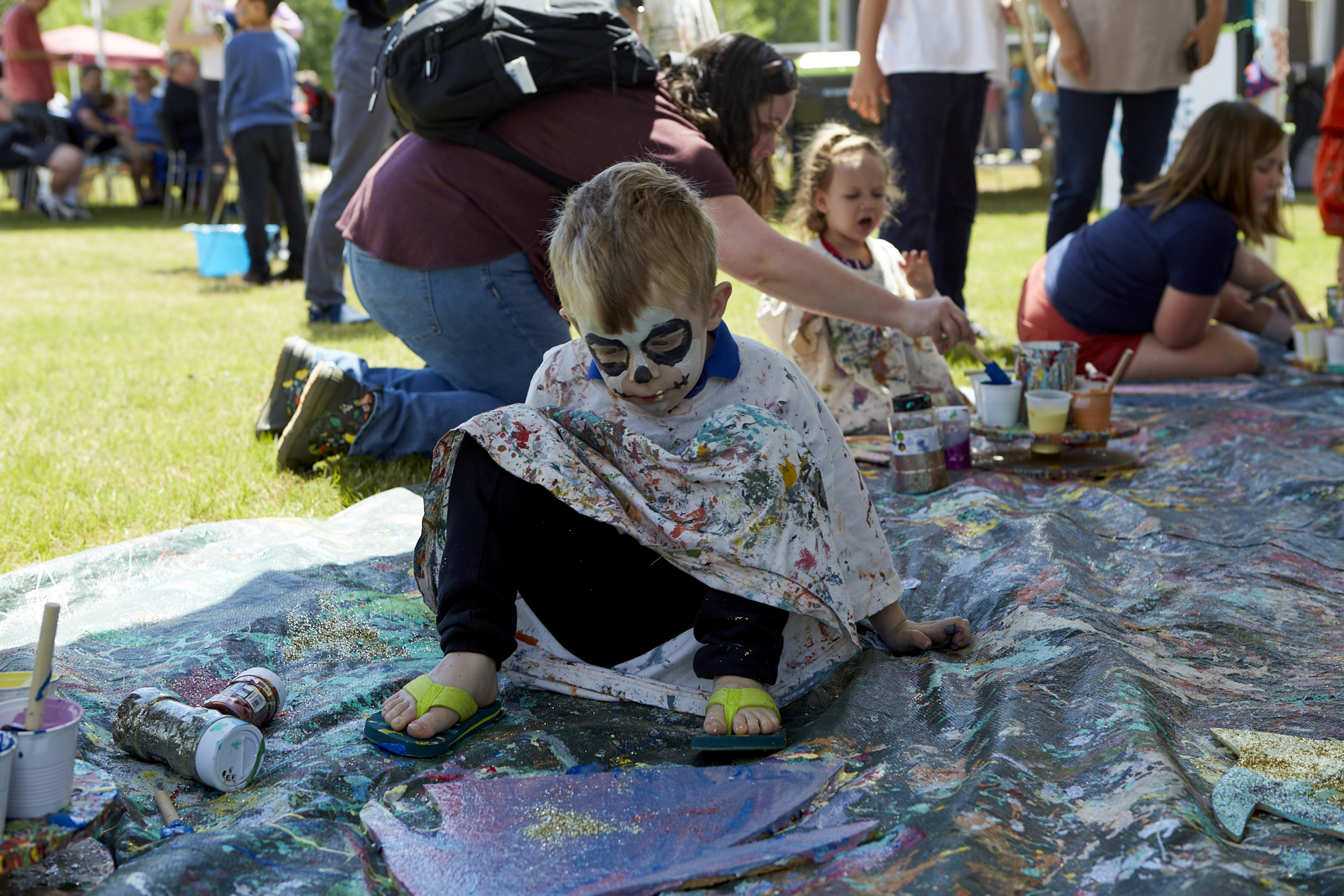 Photo of small boy with face painted like a skeleton looking at his painted critter