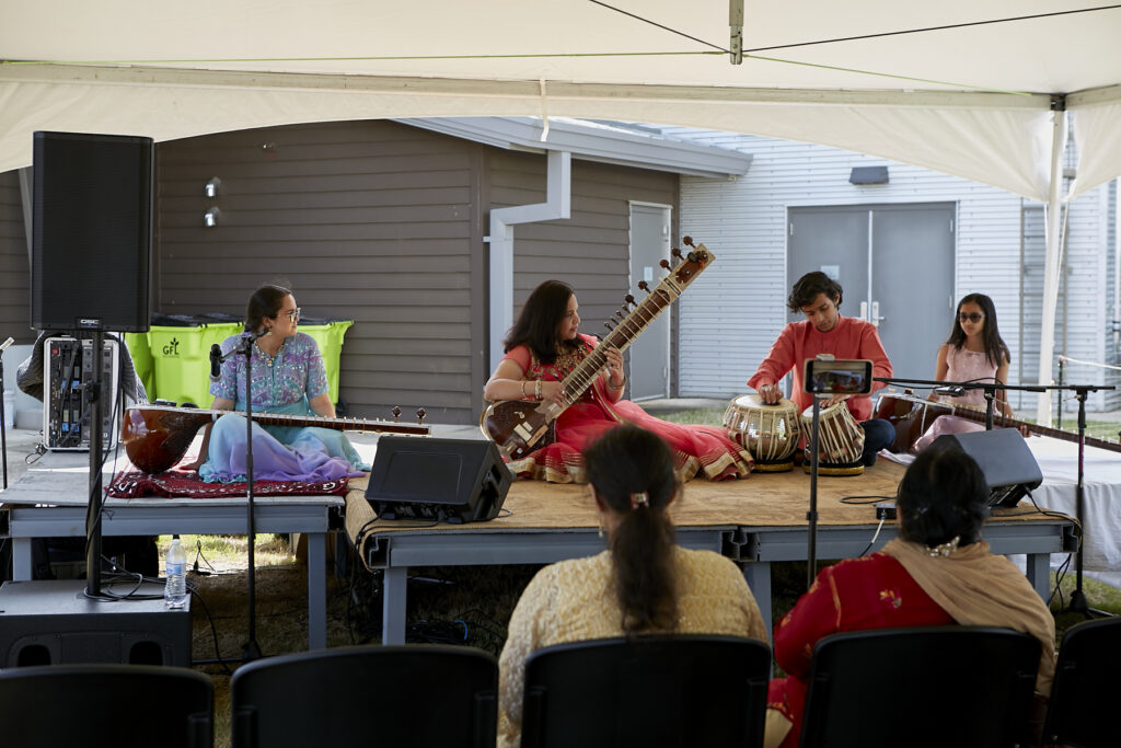 Photograph of 3 women and 1 man sitting on the ClydeFEST 2023 stage, playing sitar