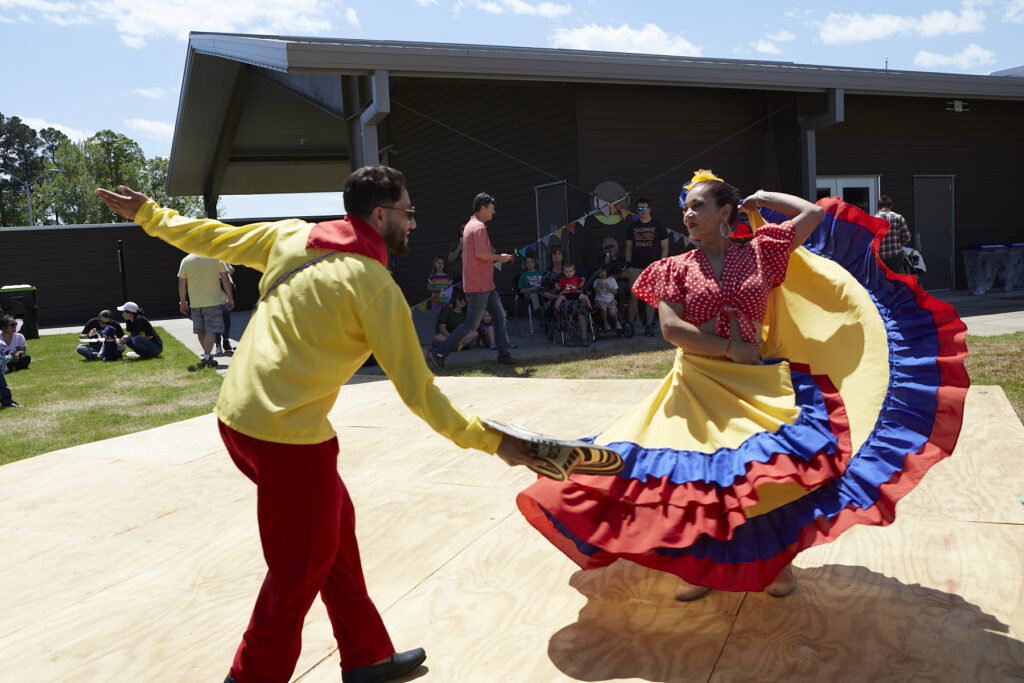 Photo of 2 dancers from Takiri Folclor Latino in brightly colored traditional costumes