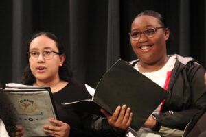 Photo of 2 teen girls holding music folios