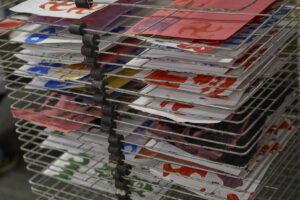Photo of drying stamp art stacked on a metal rack.