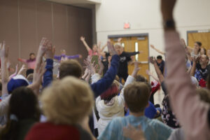 Photo of audience of elementary students raising their hands at the Black Box Dance Theatre performance