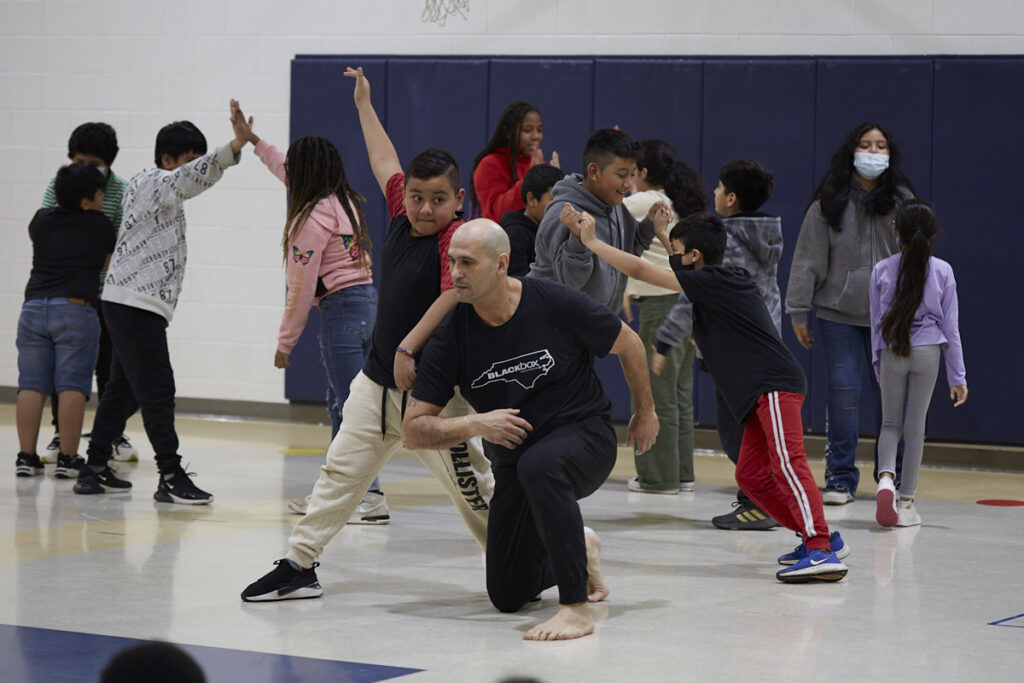 Photo of Alfredo of Black Box Dance Theatre dances with student from Virginia Cross Elementary