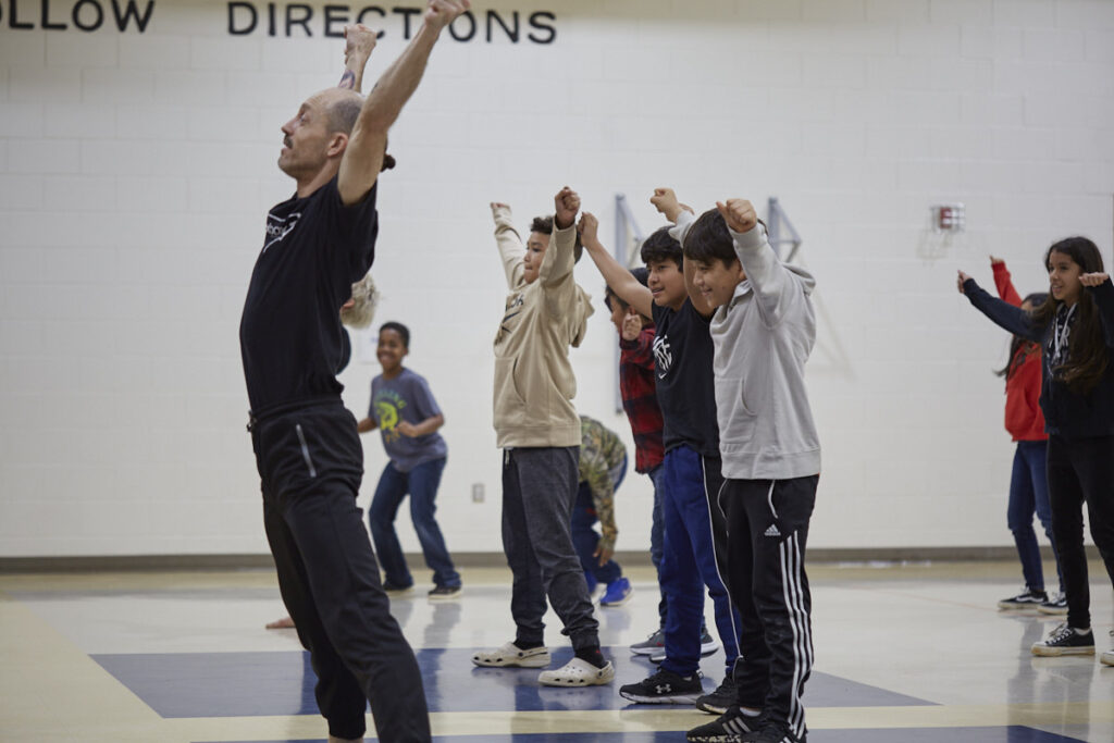 Photo of Stephen from Black Box Dance Theatre leading students from Virginia Cross Elementary
