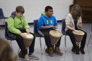 Photo of three students playing drums