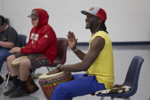 Photo of Diali Cissokho with a drum, holding class at Bonlee school