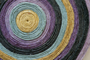 Round textile pattern with brown, blue, purple, and navy colors.