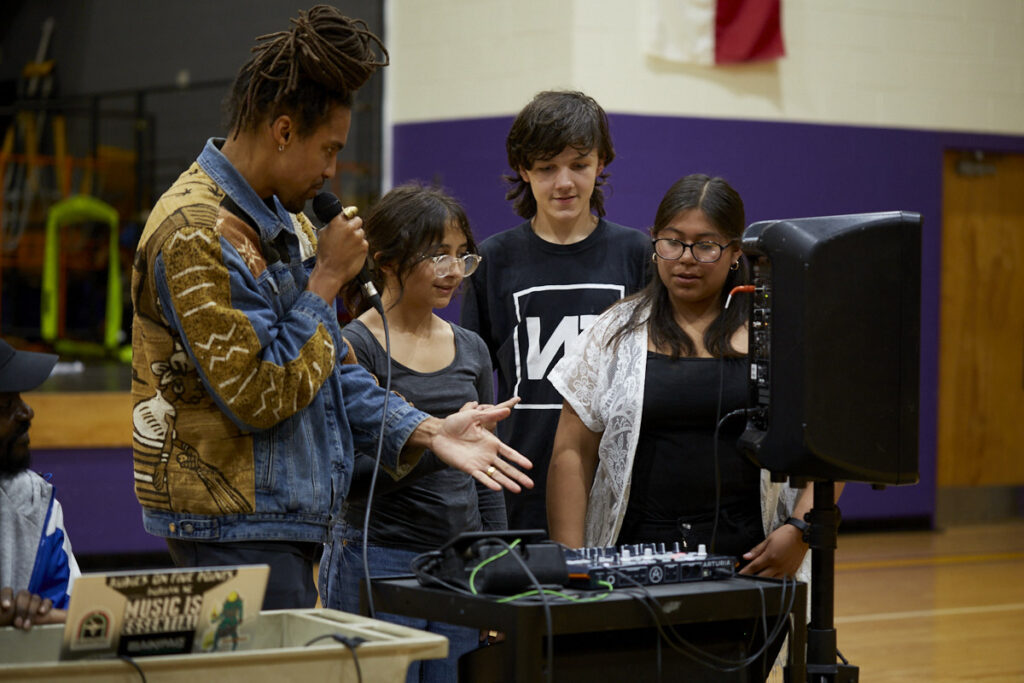 Students gather at a beat making station, ready to share their beats