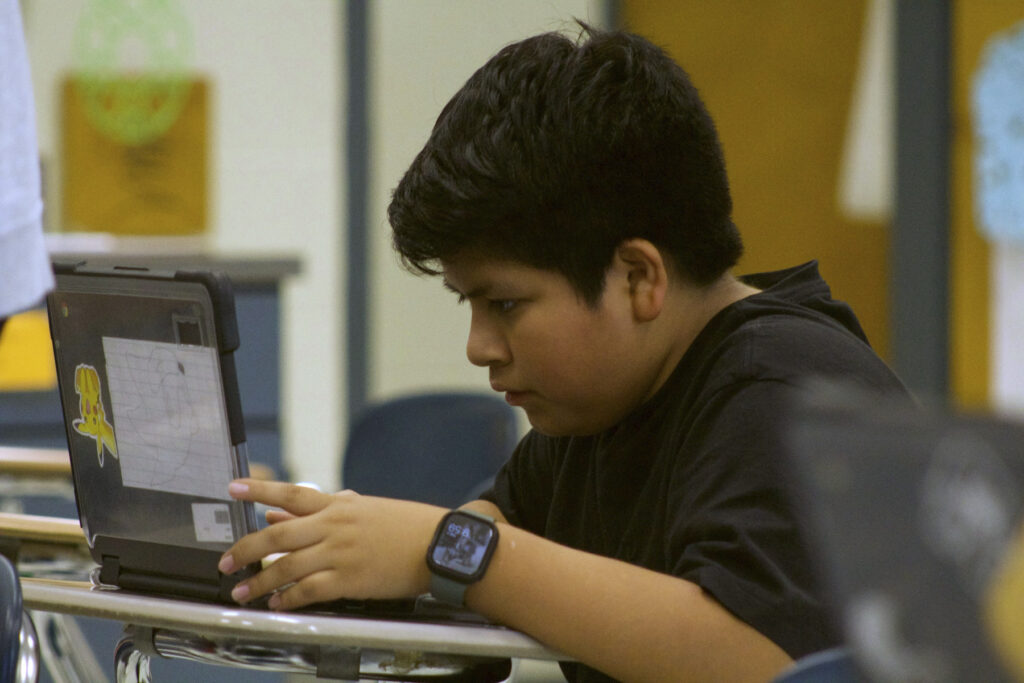 A student works on his computer to create electronic beats