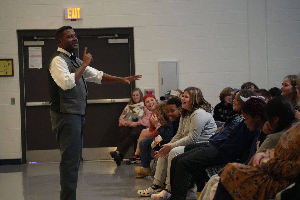 Mike Wiley acts in front of an audience of students.