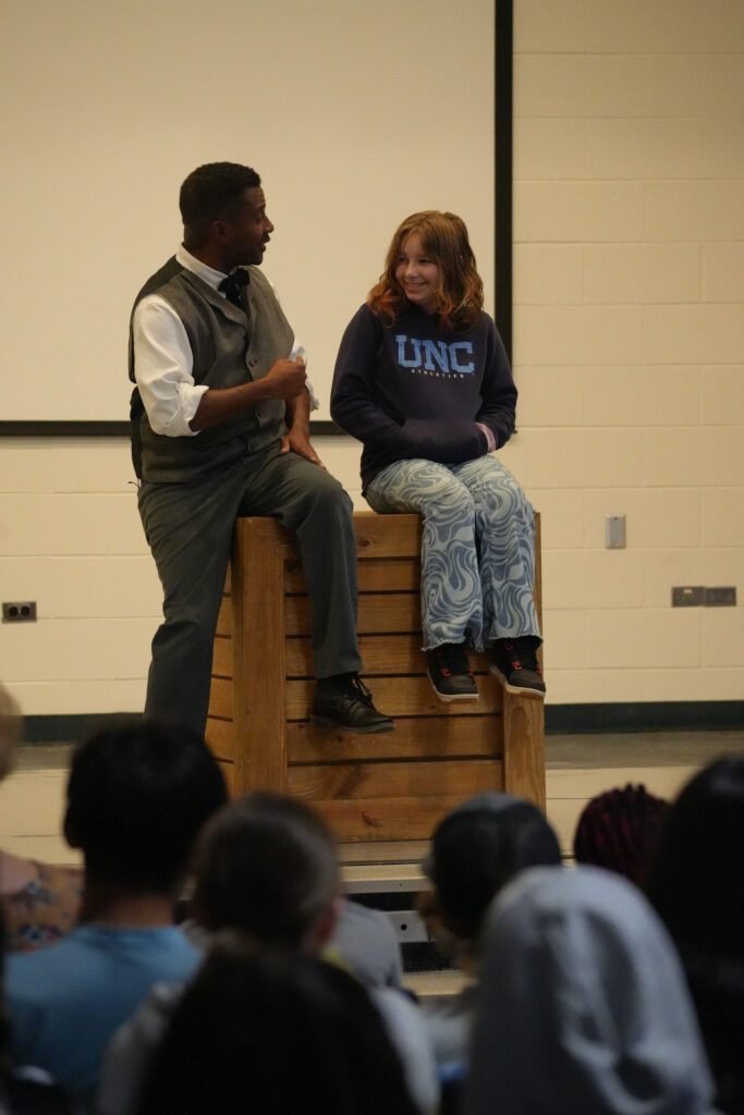 Mike Wiley acts alongside a student.