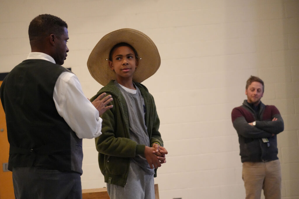 Mike Wiley acts alongside a student.
