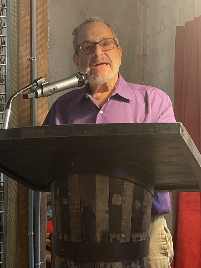 White man stands behind a podium
