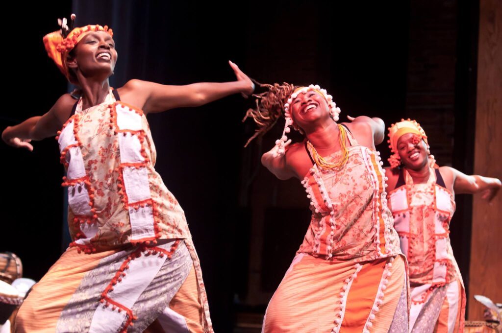 Photo of group of women wearing traditional African dress, dancing