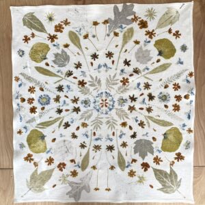 Square cloth with white background, and colorful plant prints.