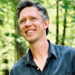 Photo of White man in dark shirt smiling