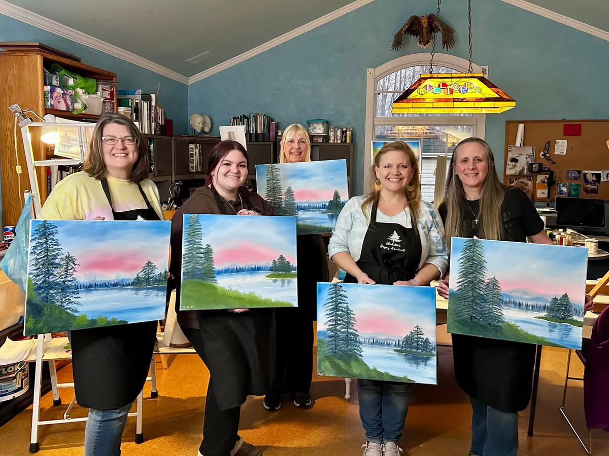 a group of women displaying a painting study of landscapes.