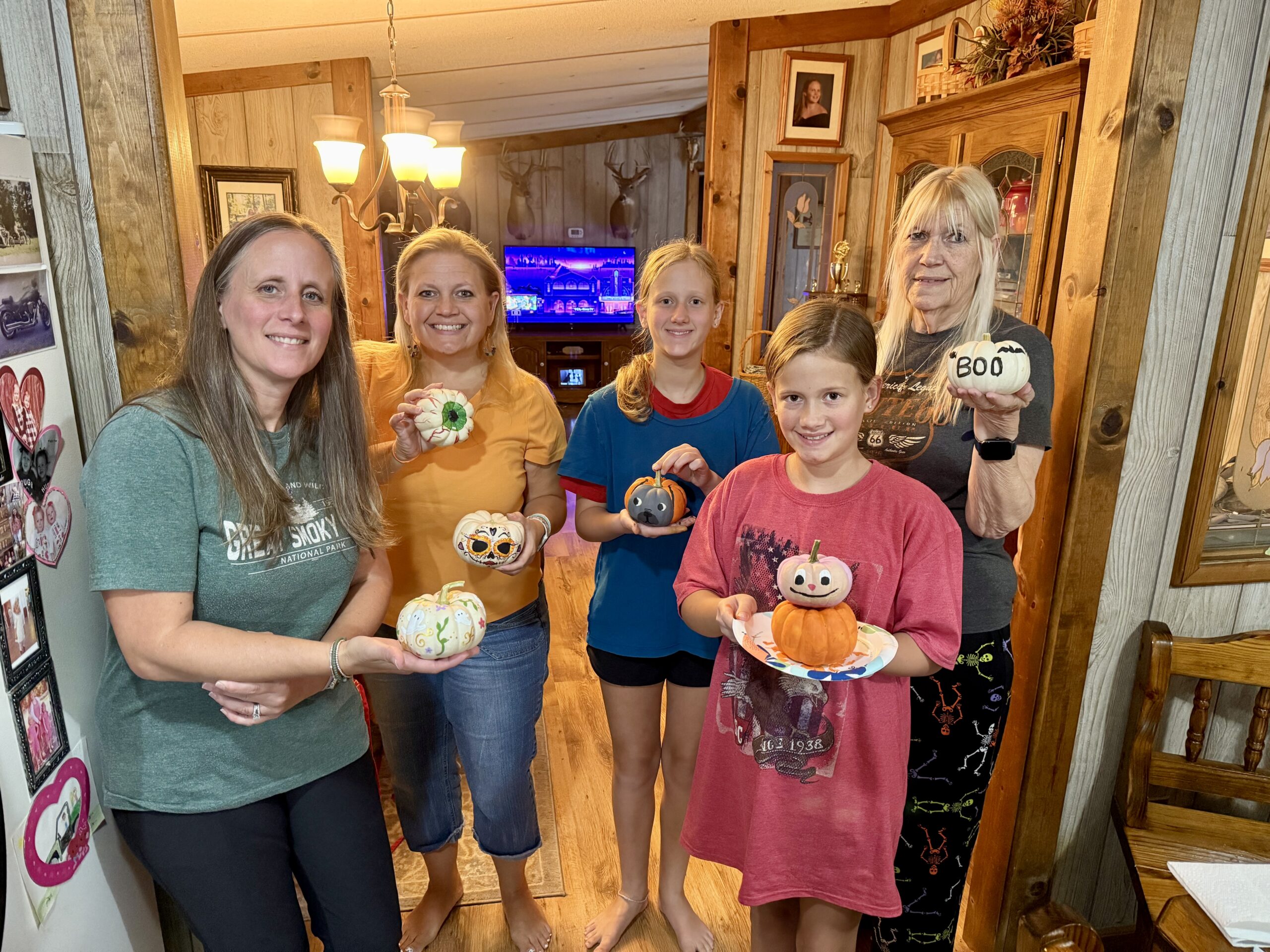 a family displays painted pumpkins.