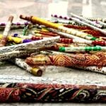 Colorful folk dance sticks in a pile on shiny multipurpose room floor at a school.