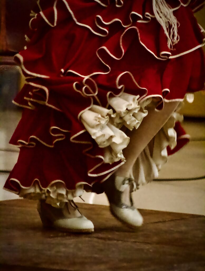 Close-up of Flamenco dancer's red ruffled skirt and high-heeled shoes