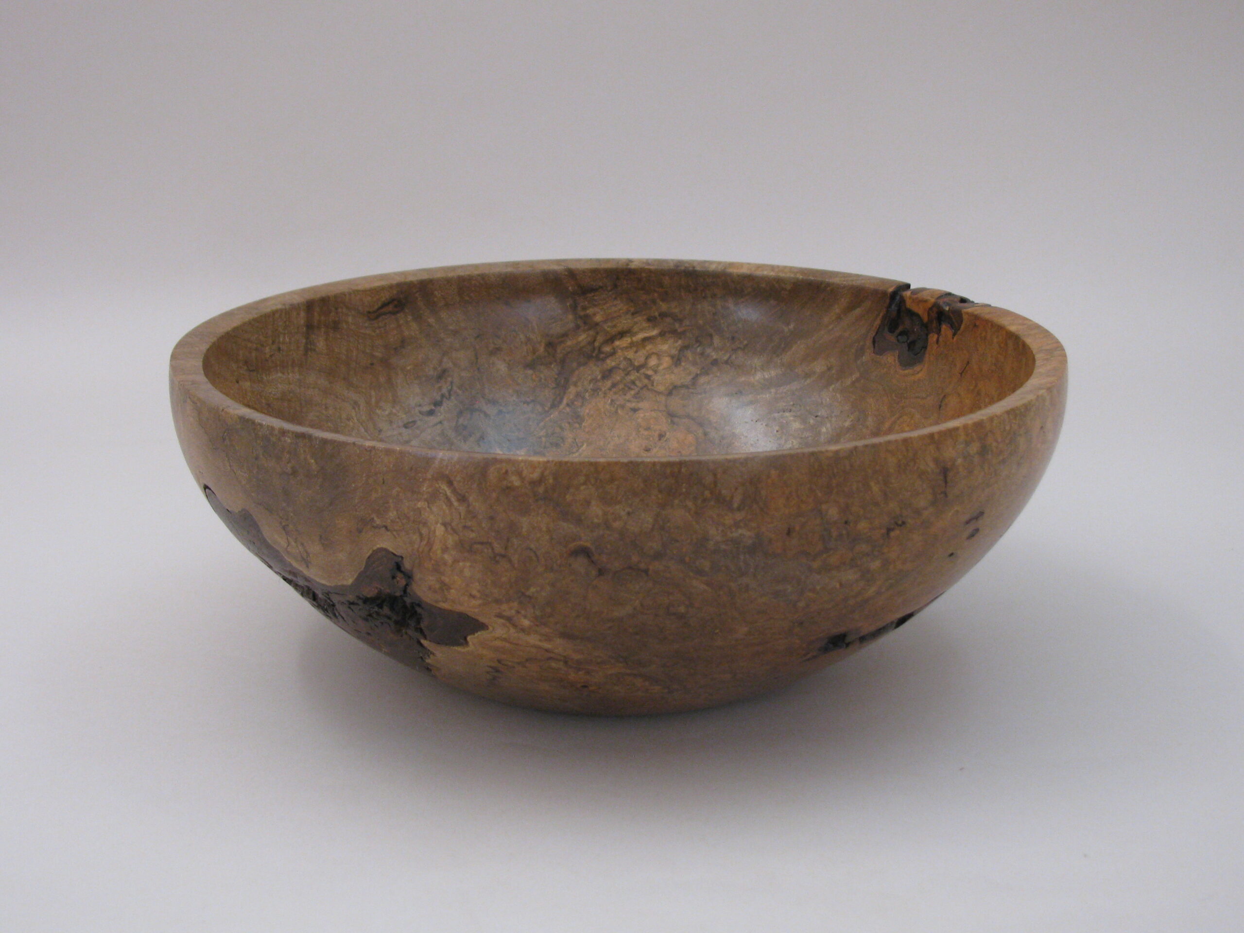a studio photo of a wooden bowl.
