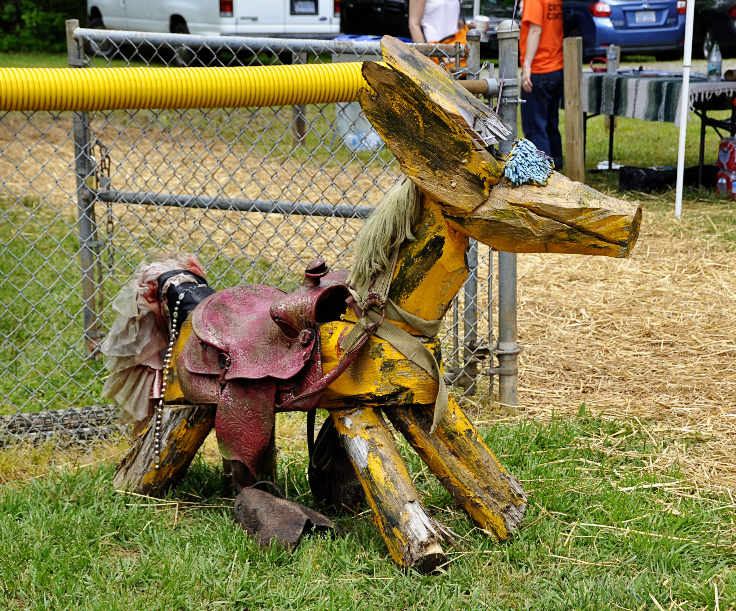 Clyde Jones critter yellow wood sculpture with a red saddle