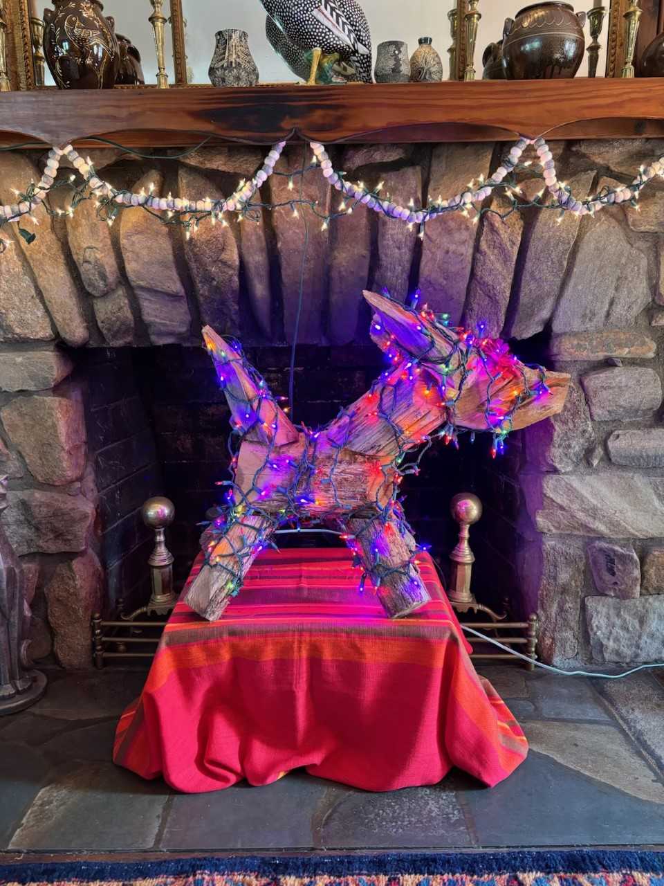 Clyde Jones wood dog sculpture decorated with twinkling lights
