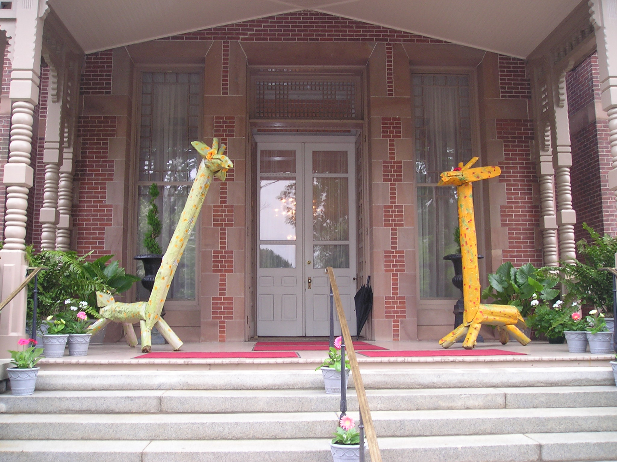 Two Clyde Jones giraffe sculptures on the steps of the Governor's Mansion