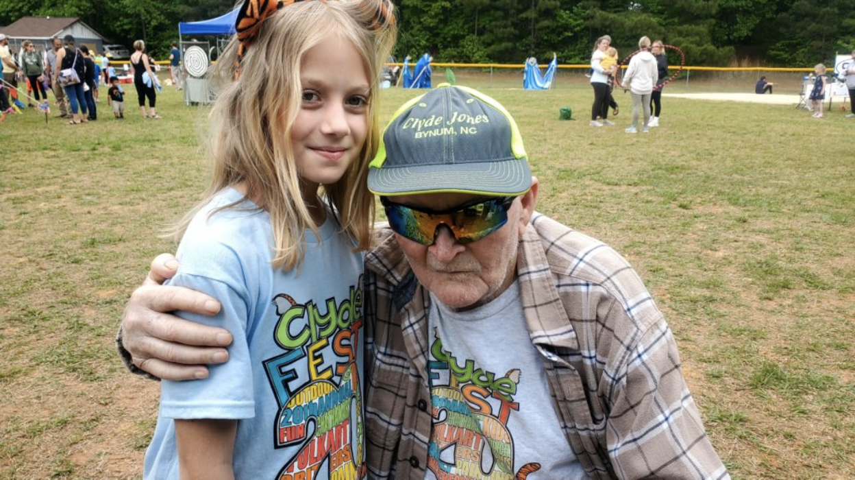 Young girl with blonde hair, hugging Clyde Jones at ClydeFEST
