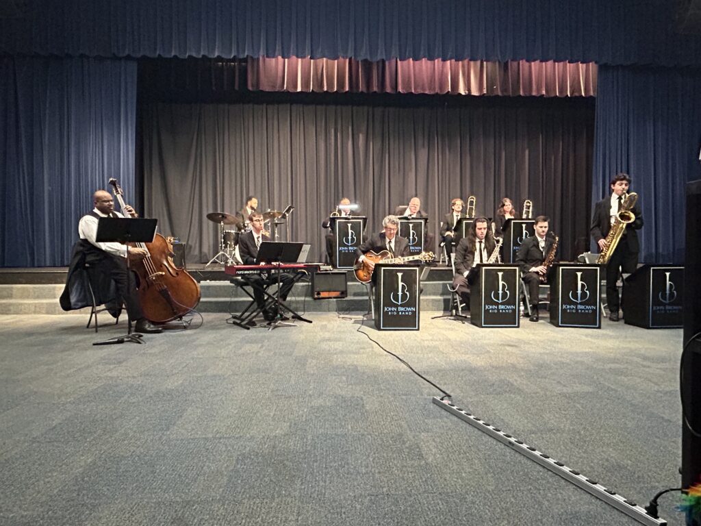 John Brown Little Big Band set up in front of stage, playing jazz music.