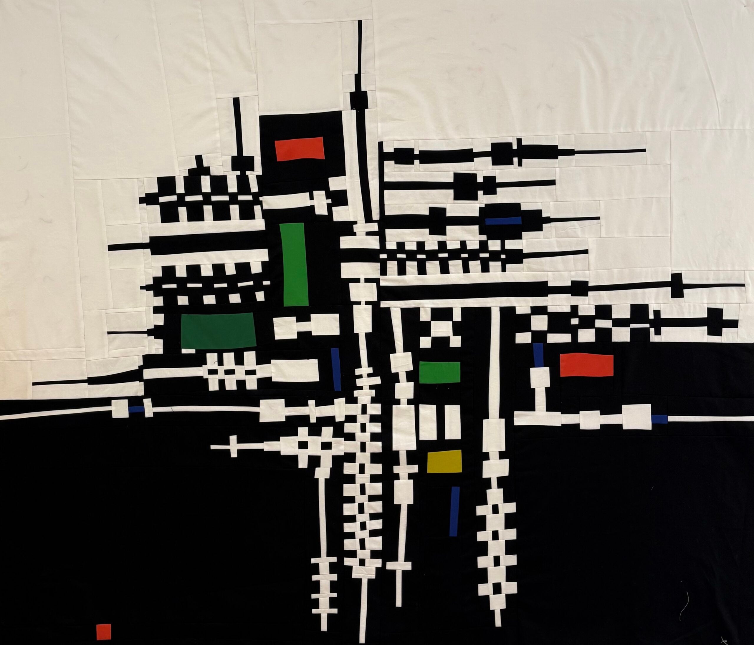 a black and white geometric quilt top with pops of primary colors
