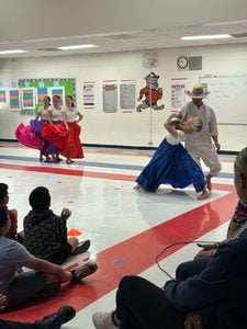 Black Box Dance Theatre dancers in flowing skirts perform for students in the Siler City Elementary gym.